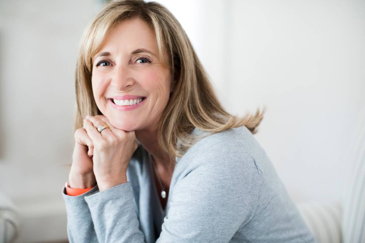 Lächelnde erwachsene Patientin als Symbol für moderne Alterszahnheilkunde in Delmenhorst